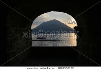 stock-photo-shooting-through-a-window-sill-towards-sunset-at-lake-como-italy-1081356122
