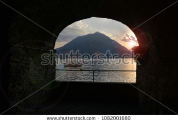 stock-photo-shooting-through-a-window-sill-towards-sunset-at-lake-como-italy-1082001680